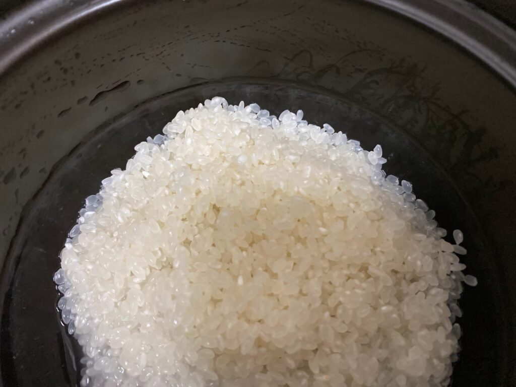 洗った米を釜に入れた写真